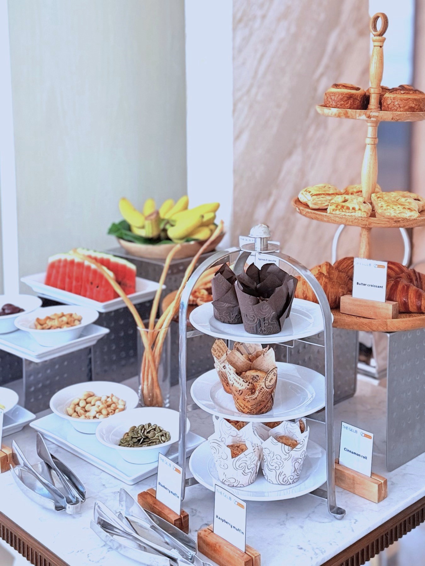 A delightful selection of pastries, fresh fruits, nuts, and snacks, beautifully displayed for complimentary high tea at THE QLUB, SILQ Hotel Bangkok, available daily from 3:00 to 5:00 PM.