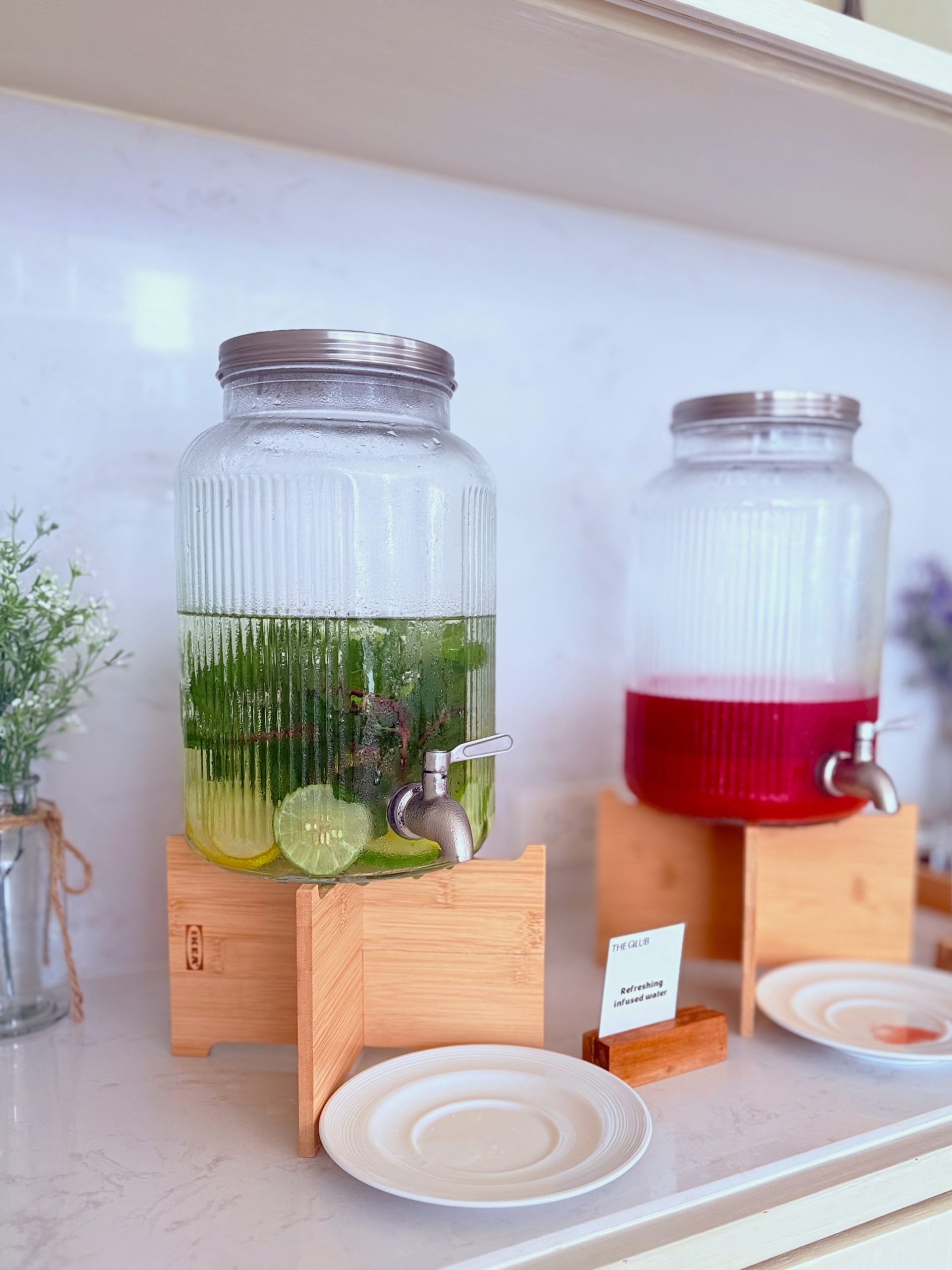 Two large glass dispensers filled with refreshing infused water—one with lime and mint, and the other with a red fruit infusion—available at THE QLUB, SILQ Hotel Bangkok.